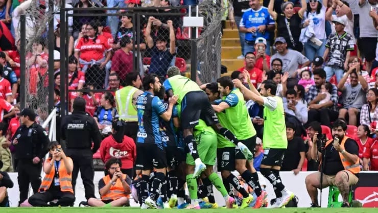 Soccer players in bright green uniforms celebrating with a crowd of spectators in the stadium background