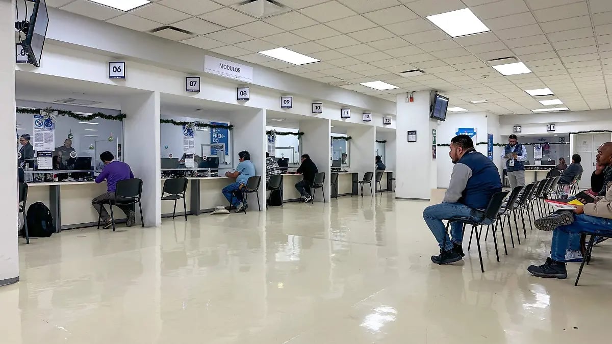 Interior of a bank or government office with teller windows and customers waiting in chairs on a polished floor